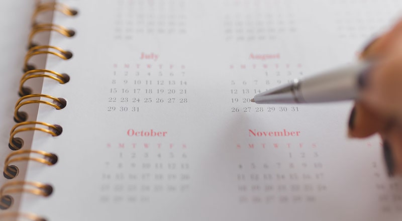 девушка отмечает ручкой в календаре