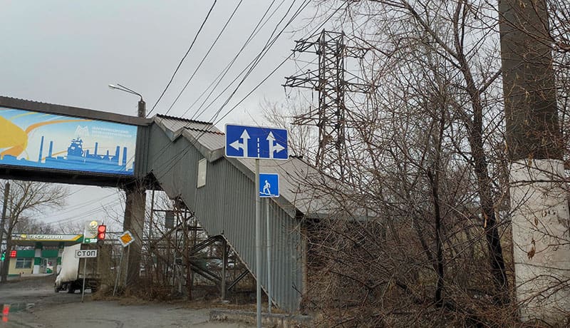 знак направление движения по полосам на столбе за городом