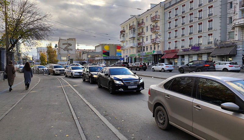 автомобили и пешеходы на дороге города