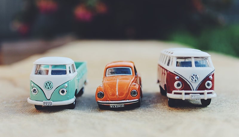 игрушечные автобусы и автомобиль стоят в ряд
