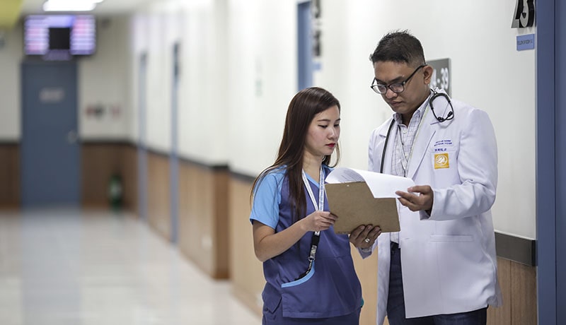 2 врача стоят в коридоре больницы