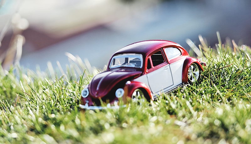 игрушечная красная машинка стоит на траве