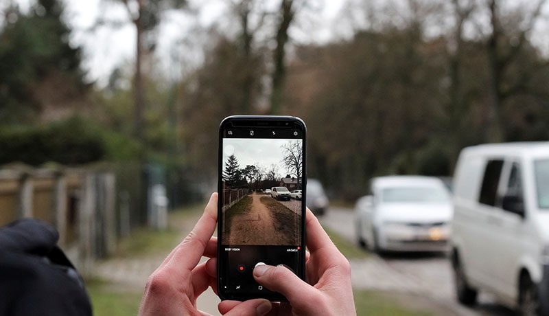 парень фотографирует автомобиль