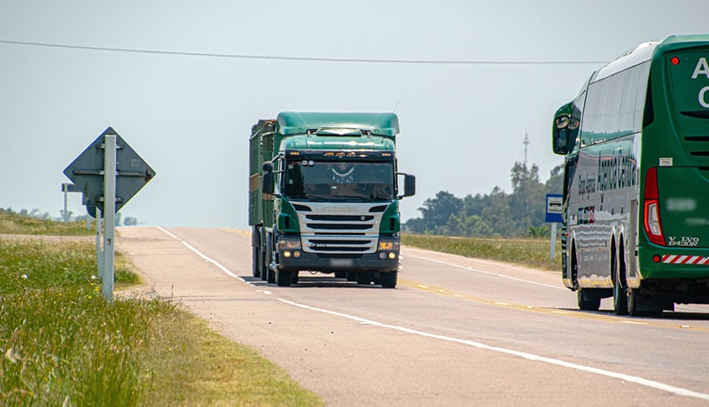 зеленый грузовик едет по дороге