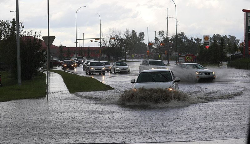автомобили едут по затопленной улице