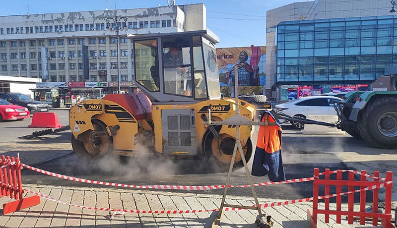 желтый асфальтоукладчик на дороге