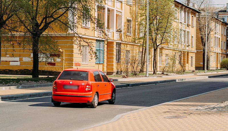 красная машина едет по дороге