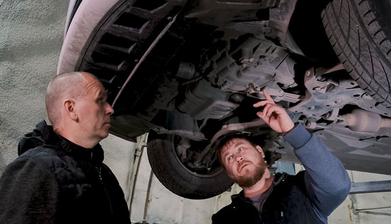 мужчины проверяют состояние автомобиля
