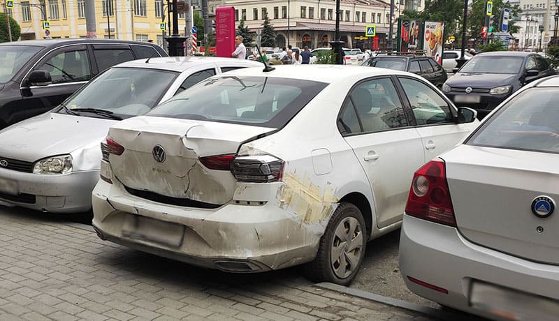 помятый зад белого автомобиля