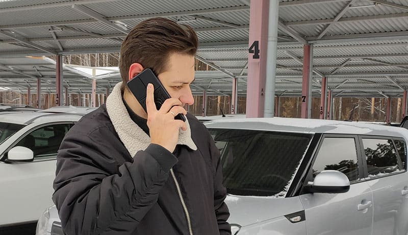 мужчина разговаривает по телефону рядом с машиной