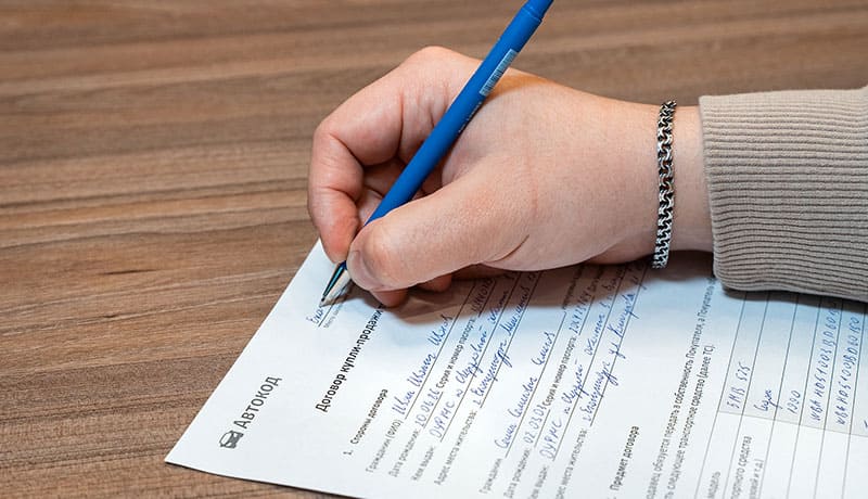 мужчина заполняет документ купли-продажи
