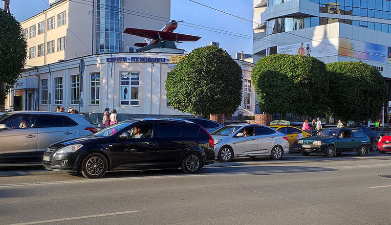 автомобили стоят на светофоре в городе