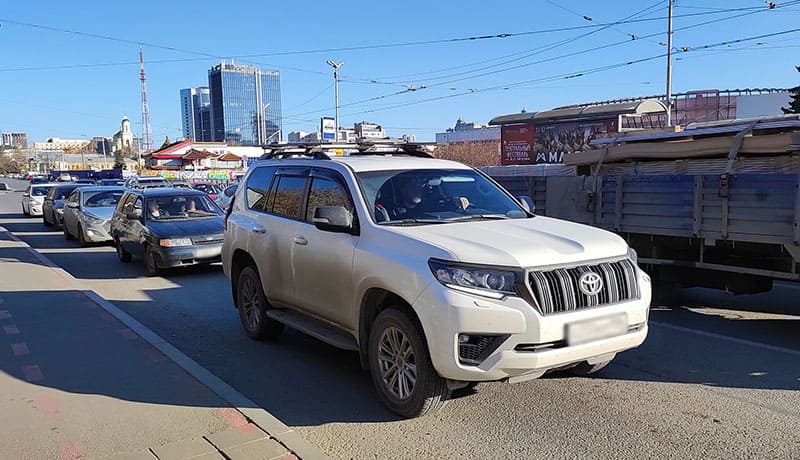 белый автомобиль внедорожник тойота на дороге