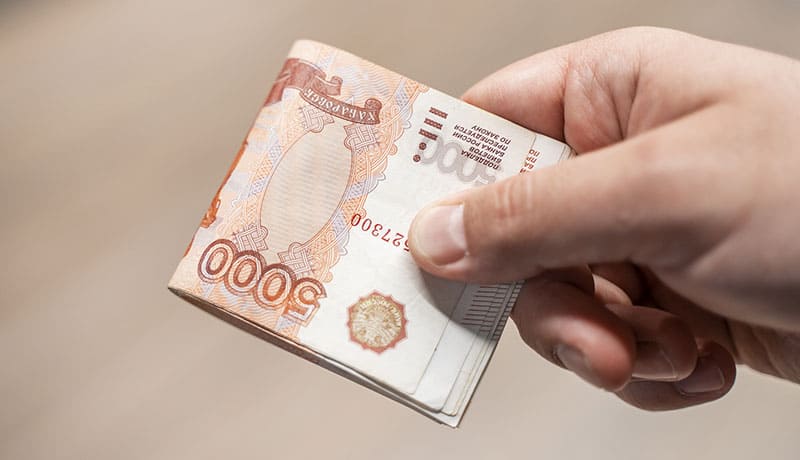 мужчина держит в руке купюру
