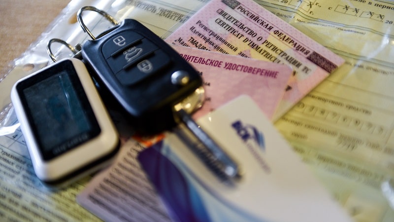 ключи от машины, стс и водительское удостоверение лежат на столе